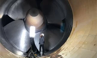 Arbeiterin vor gigantischem Turbinen-Laufrad