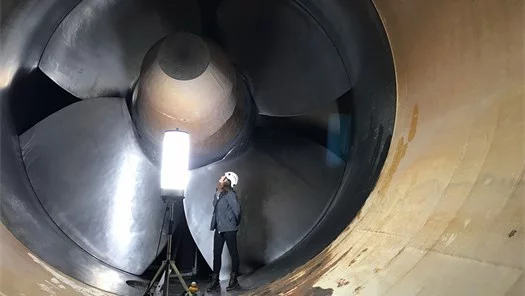 Arbeiterin vor gigantischem Turbinen-Laufrad