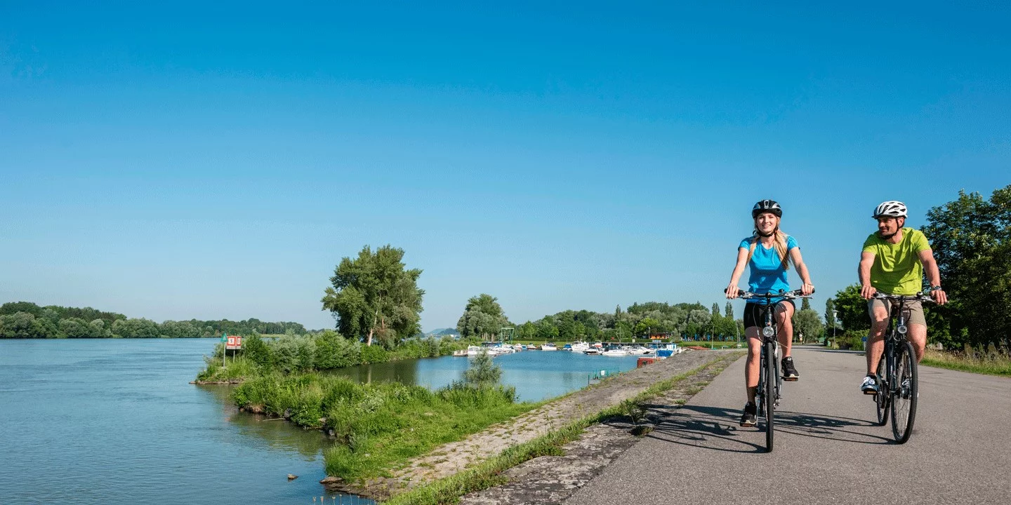 Donauradweg: Zwei Radfahrer fahren entlang der Donau.